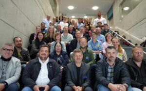 Gruppenbild von rund 50 Teilnehmenden des TOBIS-Netzwerkworkshops auf einer Treppe im Veranstaltungsgebäude, aufgenommen nach dem Auftakt.